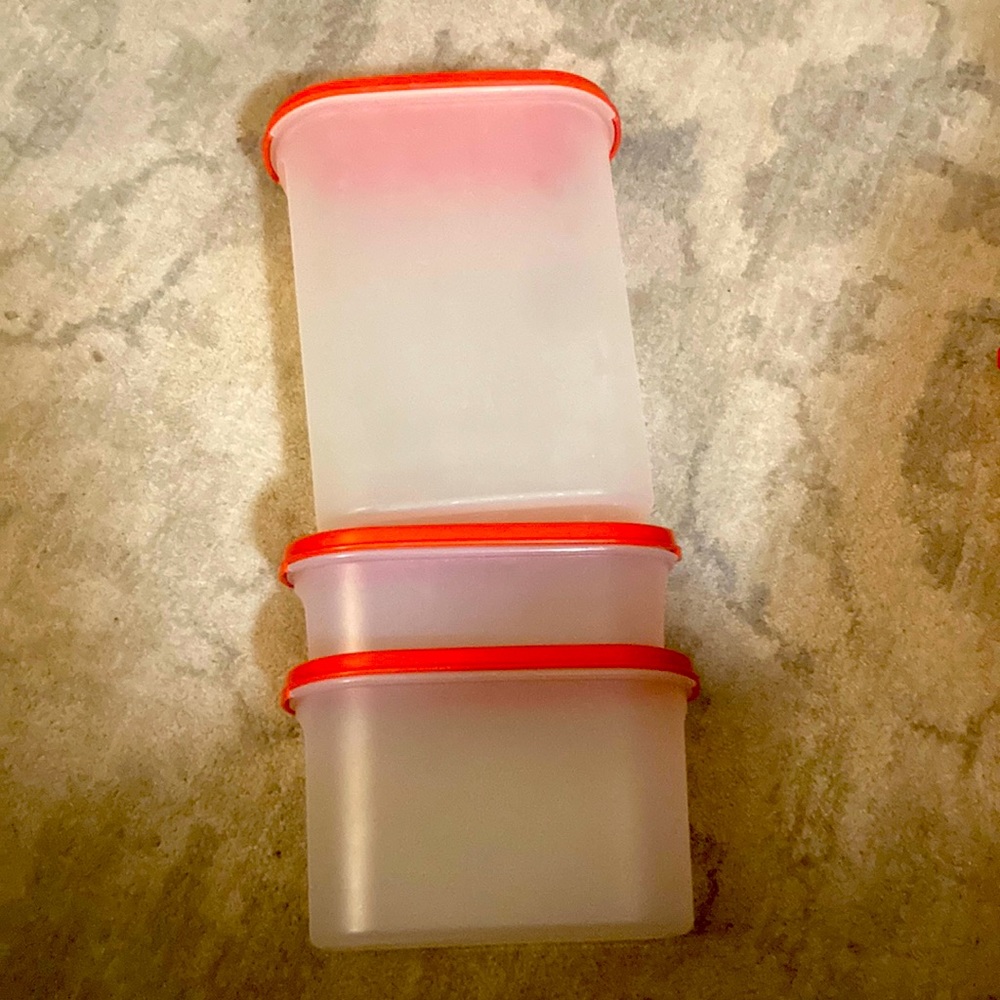 Three Tupperware containers with red lids